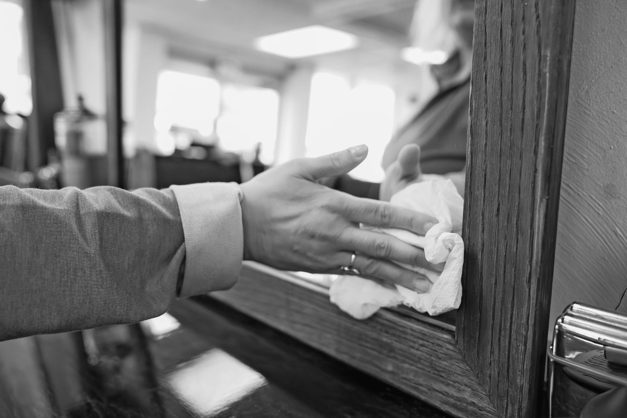 A professional wiping a mirror.